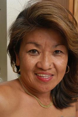 Dottie, une asiatique mature, se met nue dans sa cuisine.